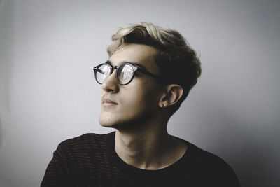 Close-up of thoughtful young man against white background