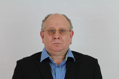 Portrait of man wearing eyeglasses against white background