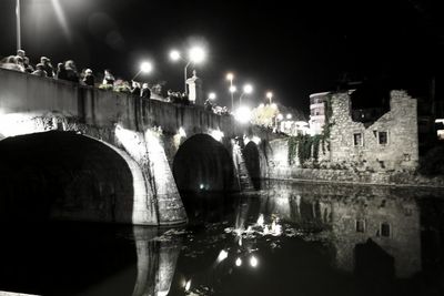 Reflection of illuminated bridge over river at night