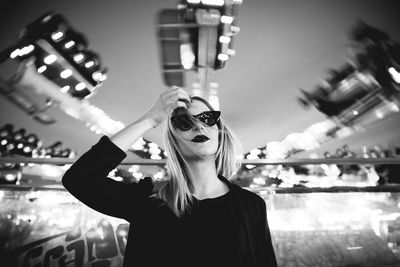 Portrait of young woman wearing sunglasses standing outdoors