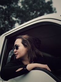 Woman in sunglasses looking through window of car