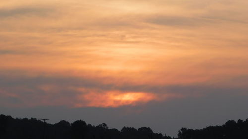 Low angle view of silhouette trees against dramatic sky