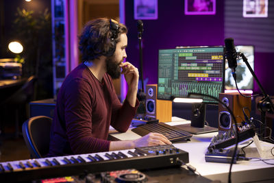 Young woman using mobile phone in recording studio