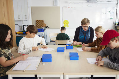 Students and teacher sitting in classroom