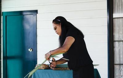 Side view of senior woman standing against wall