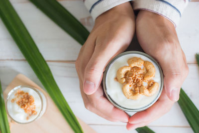 High angle view of hand holding coffee cup on table