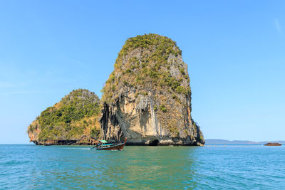 Sailboat on rock in sea against clear sky