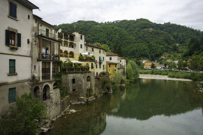 Buildings by lake against mountain