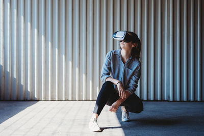 Young woman with vr goggles outdoors posing, virtual reality experience