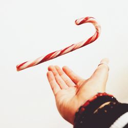 Close-up of hand holding red over white background