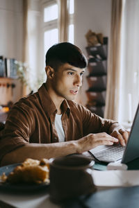 Male freelancer working on laptop at home office