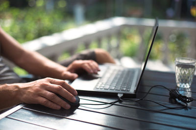 Cropped hands of woman using laptop