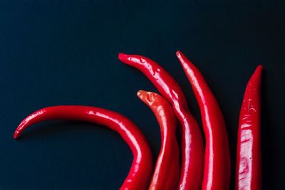 Close-up of red chili peppers on table against black background