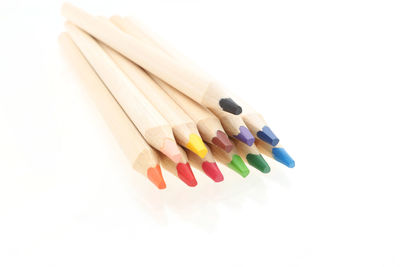 High angle view of multi colored pencils on white background