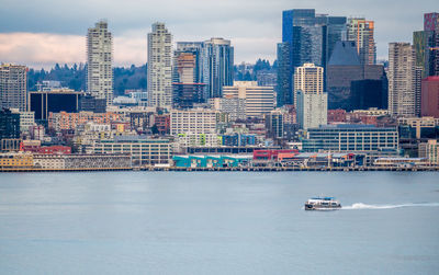 Nautical vessel on sea against buildings in city