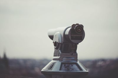 Close-up of coin-operated binoculars against sky