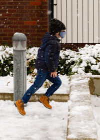 Full length of boy running in the snow