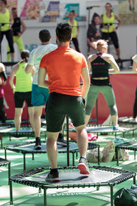 Rear view of people standing against the wall