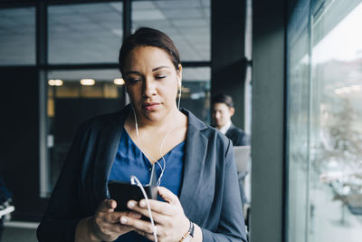 Young woman using mobile phone at camera