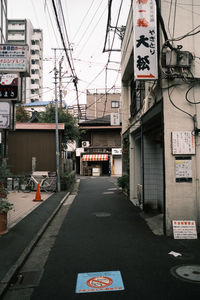 Road sign on street amidst buildings in city