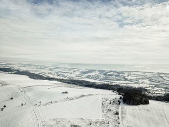 Scenic view of snow covered field against sky