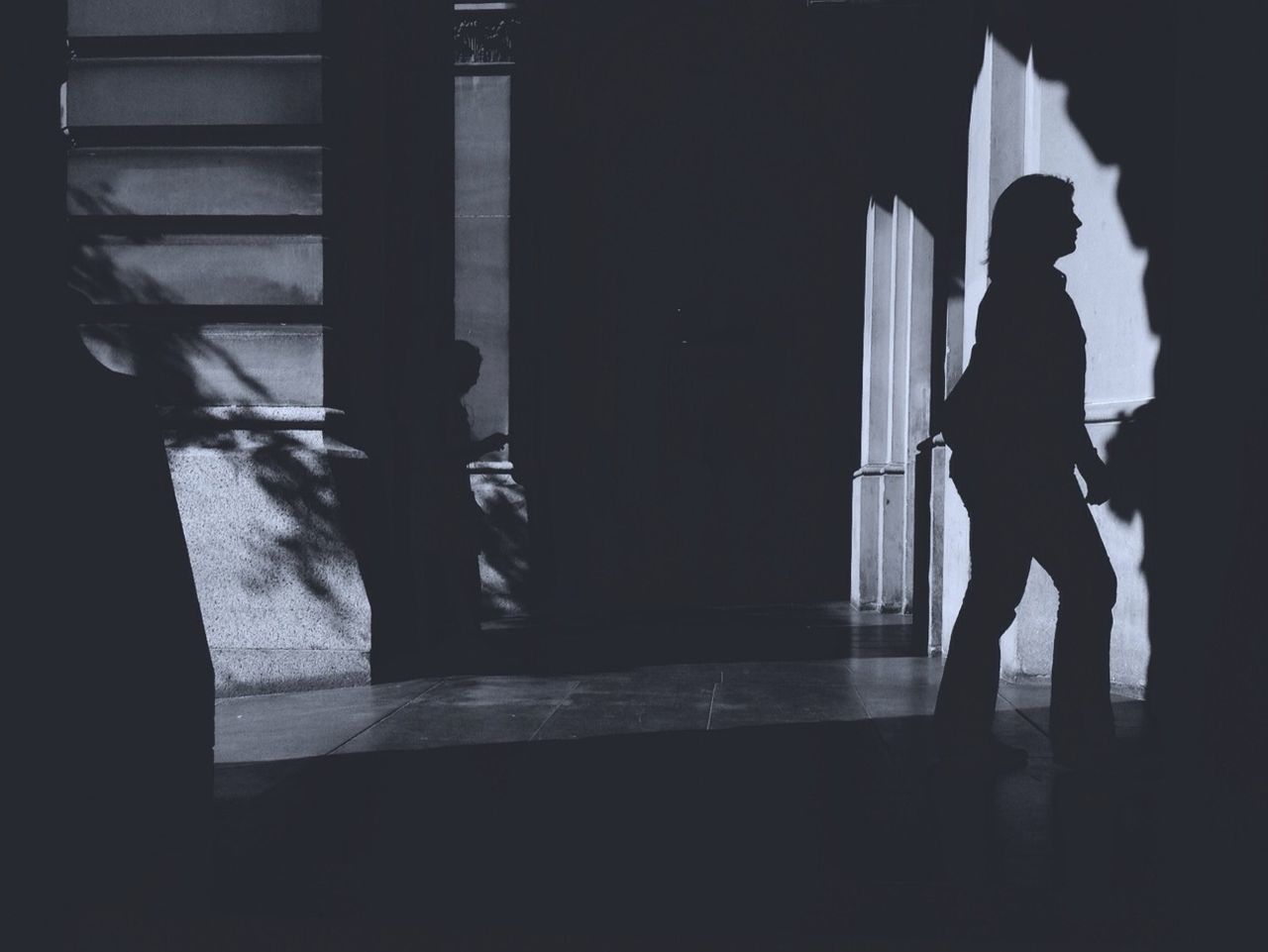 indoors, architecture, silhouette, built structure, rear view, standing, men, full length, dark, walking, window, shadow, lifestyles, person, wall - building feature, corridor, sunlight, wall