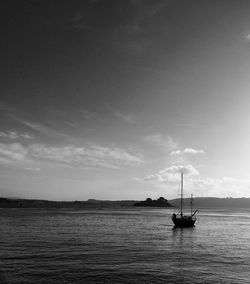 Silhouette sailboat in sea against sky