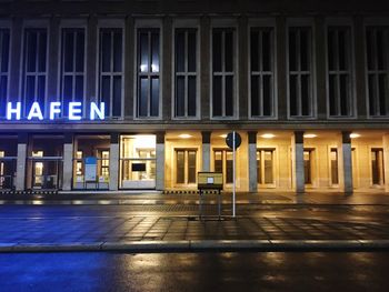 Empty parking lot by building at night