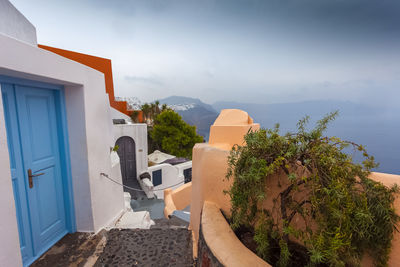 Houses by sea against sky