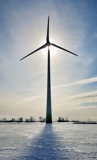 Traditional windmill against sky during sunset