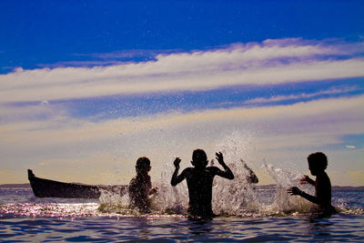 Men swimming in sea against sky at night