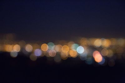 Defocused lights against sky at night