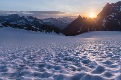 Scenic view of snowcapped mountains against sky during sunset