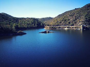 Scenic view of lake against clear blue sky