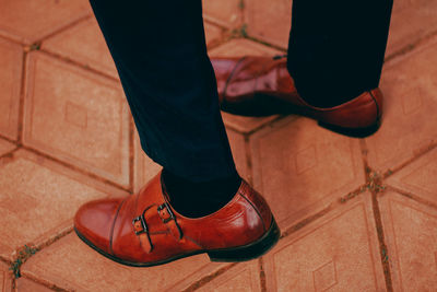 Low section of man standing on tiled floor