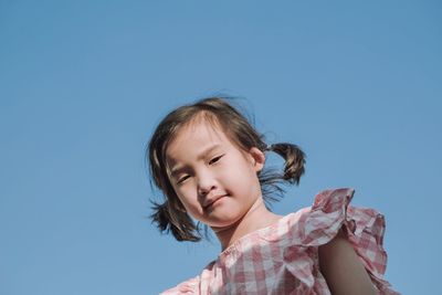 Portrait of girl against clear blue sky