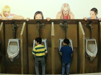 Full length of young man standing against wall