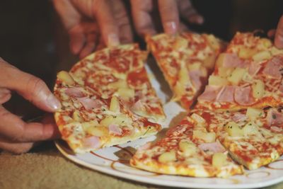 Close-up of hand holding pizza