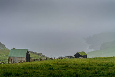 Houses on field against sky