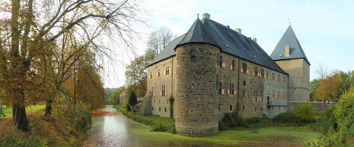 Panoramic view of old building amidst trees against sky