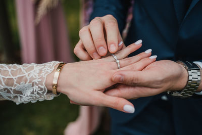 Midsection of couple holding hands