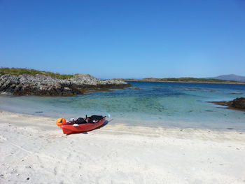 Boat on beach against clear sky