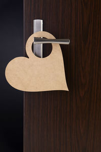 Close-up of paper hanging on wooden table against wall