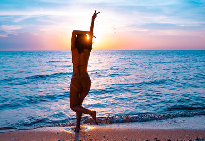 Man standing at beach during sunset