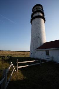 Lighthouse amidst buildings against sky