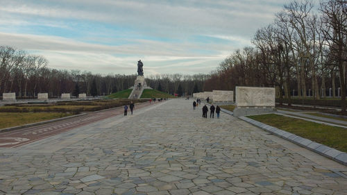 Footpath in park against sky