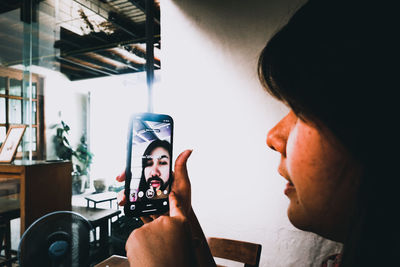 Portrait of woman photographing through smart phone