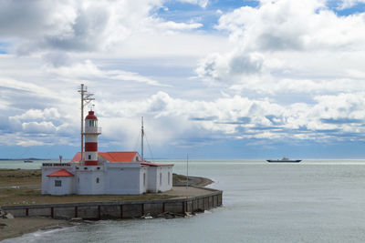 Lighthouse by sea against sky