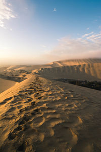 Scenic view of desert against sky during sunset