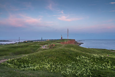 Scenic view of sea and buildings against sky during sunset